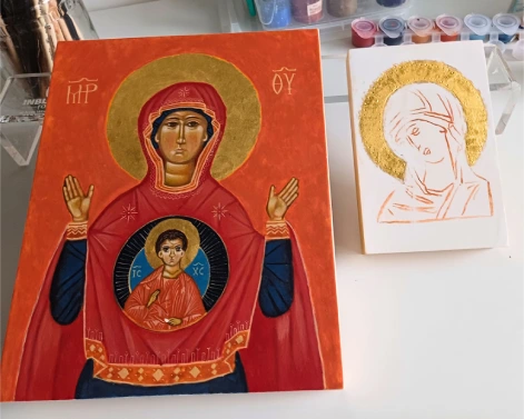 Two Authentic Byzantine icons of the Mother of God handcrafted on wood. The first is a completed Mother of God 'The Sign' icon, ready for worldwide shipping. The second is a Theotokos Virgin Mary icon in progress on a linden panel, shown after gilding with genuine gold leaf but before egg tempera painting, showcasing traditional sacred craftsmanship.