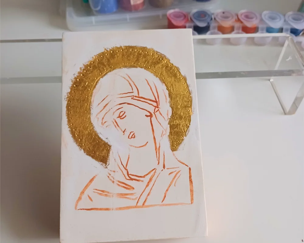 Finished water gilding in iconography on a Theotokos icon board, showing a high-gloss burnished gold leaf halo before the painting process begins.