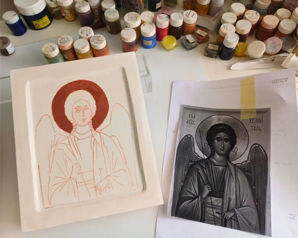 In-progress hand painted Guardian Angel Icon on linden wood showing the gilding process on bole before egg tempera painting.